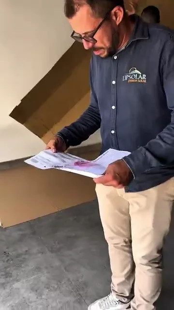 Técnico conferindo documentos durante entrega de equipamentos solares